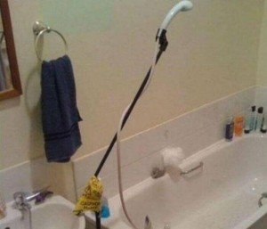 Dish sprayer attached to a microphone rod suspended above a bath tub used as shower head.